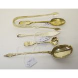 AN IRISH GEORGIAN BRIGHT CUT SUGAR TONGS; three assorted spoons; and a butter knife. (5)