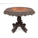 A FINELY CARVED PIERCED CIRCULAR BURMESE HARDWOOD CENTRE TABLE, the top with a carved band depicting