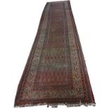 AN IRON RED GROUND PERSIAN RUG
