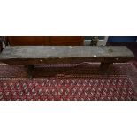 AN OLD PLANK TOP WOODEN BENCH