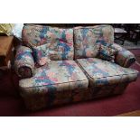 A MODERN TWO SEATER EASY SETTEE, with loose cushion back and seat, covered in attractive floral