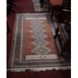 A TURKISH CARPET, with a row of six octagons, inside a multi band border, in a fawn ground 6ft2 (