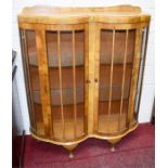 AN ART NOUVEAU STYLE WALNUT DOUBLE BOW FRONTED DISPLAY CABINET,