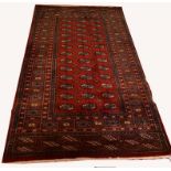 A BURGUNDY GROUND BOKHARA RUG