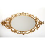 A PAIR OF OVAL GILT CAST METAL WALL MIRRORS OR PIER MIRRORS