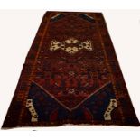 A BURGUNDY GROUND FULL-PILE PERSIAN HAMADAN RUG