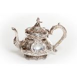 AN IRISH CRESTED AND EMBOSSED SILVER TEA POT