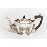 A SMALL EMBOSSED SILVER TEAPOT