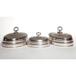 A SET OF THREE OVAL SILVER PLATED DISH COVERS