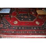 A LARGE BURGUNDY GROUND TURKISH CARPET