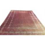 A LARGE DARK RED GROUND BOKHARA CARPET