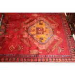 A BURGUNDY GROUND FULL-PILE PERSIAN VILLAGE RUG