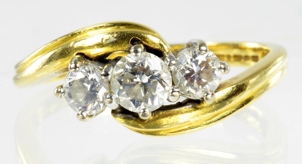 A DIAMOND THREE STONE CROSSOVER RING IN 18CT GOLD, 4.5G