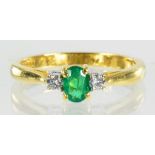 AN EMERALD AND DIAMOND THREE STONE RING WITH STEP CUT EMERALD IN 18CT GOLD, 2.6G