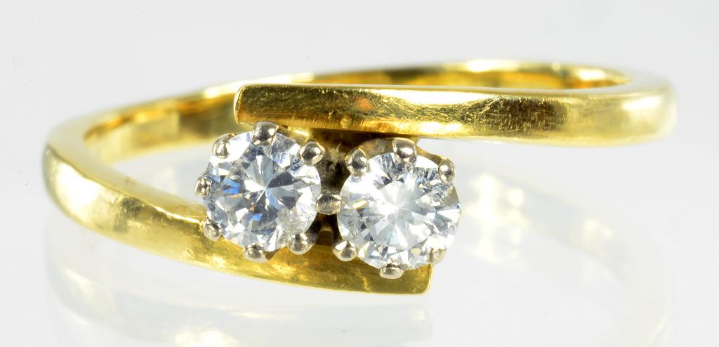 A DIAMOND TWO STONE CROSSOVER RING IN 18CT GOLD, 3.8G