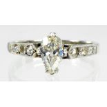 A DIAMOND RING WITH LARGER PEAR SHAPED DIAMOND IN DIAMOND SET SHOULDERS IN WHITE GOLD, MARKED 18CT &