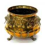 A DECORATIVE EMBOSSED BRASS JARDINIERE WITH LION MASK HANDLES AND PAW FEET, DECORATED WITH CHERRIES,