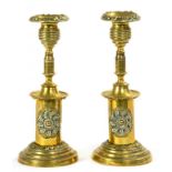 A PAIR OF VICTORIAN TURNED AND EMBOSSED SHEET BRASS CANDLESTICKS, ON DRUM BASE, WITH IRON INSERT,