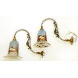 A PAIR OF BRASS MOUNTED BURNISHED STEEL EARLY ELECTRIC WALL LIGHTS WITH LANDSCAPE PAINTED GLASS