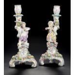 A PAIR OF SITZENDORF FIGURAL AND FLORAL ENCRUSTED CANDLESTICKS, C1900 on three scroll feet, 27cm