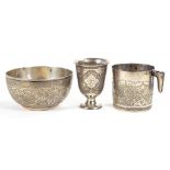 AN EASTERN SILVER BOWL, BEAKER AND MUG SIMILARLY CHASED WITH INTRICATELY DESIGN OF ARABESQUES AND