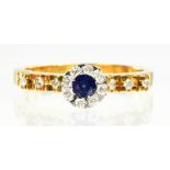 A SAPPHIRE AND DIAMOND CLUSTER RING WITH DIAMOND SHOULDERS, IN GOLD MARKED 750, SIZE O, 4.7G