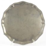 A GEORGE III SILVER SALVER WITH GADROONED RIM ON THREE HOOF FEET 25.5CM DIAM LONDON 1772, 19OZS