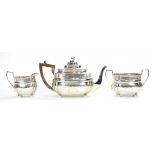 A GEORGE V SILVER THREE PIECE OBLONG TEA SERVICE WITH GADROONED RIM AND ENGRAVED WITH TRAILING