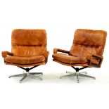 A PAIR OF 1970'S ROSEWOOD AND TAN LEATHER SWIVEL ARMCHAIRS ON CHROMIUM BASE