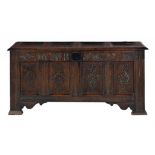 A CHARLES II OAK CHEST, DATED 1675 with four-panel lid, the frieze carved with tulips flanked by