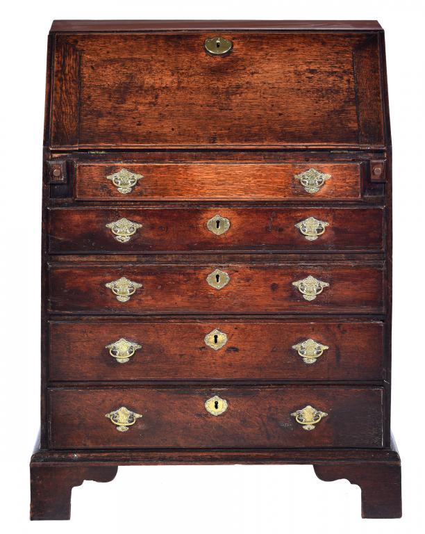 A GEORGE III OAK BUREAU of small proportions, the interior with pigeon holes, drawers and central