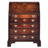 A GEORGE III OAK BUREAU of small proportions, the interior with pigeon holes, drawers and central