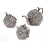 AN INDIAN SILVER REPOUSSÉ KANG TYPE 'TILTED' TEA SERVICE, KASHMIR, LATE 19TH C chased with a