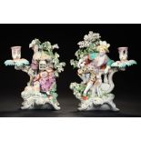 A PAIR OF DERBY CANDLESTICK FIGURES OF A SEATED SHEPHERD AND SHEPHERDESS EMBLEMATIC OF LIBERTY AND