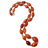 A NECKLACE OF 25 AMBER BEADS 28.7g