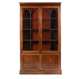 A MAHOGANY GOTHIC REVIVAL BOOKCASE, 19TH C with blind fret cornice above a pair of doors with twin