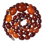 A NECKLACE OF 60 AMBER AND FATURAN BEADS 29.7g ++Three beads chipped