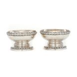 A PAIR OF GEORGE IV SILVER SALT CELLARS BY PAUL STORR with strapwork and egg and dart rims, crested,