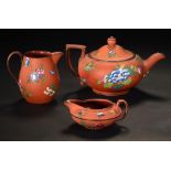 TWO WEDGWOOD ROSSO ANTICO CREAM JUGS, C1840 AND A MATCHING WEDGWOOD TEAPOT AND COVER, 1865 enamelled
