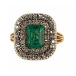AN EMERALD AND DIAMOND CLUSTER RING the step cut emerald bordered by two rows of diamonds, in