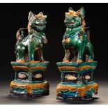 A PAIR OF CHINESE TILE WORKS GREEN AND OCHRE LEAD GLAZED MODELS OF BUDDHISTIC LIONS, MING DYNASTY,