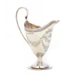 A GEORGE III SILVER CREAM JUG of helmet shape, later engraved with swags, 14cm h, maker WS, probably