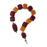 A MIDDLE EASTERN SILVER COLOURED METAL MOUNTED NECKLACE OF FIVE AMBER COLOURED AND EIGHT CHERRY