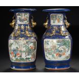 A PAIR OF CANTON BLUE GROUND FAMILLE ROSE VASES, 19TH C moulded to either side with oblong panels