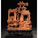 A CHINESE SANDALWOOD CARVING, 19TH C of four figures in a pavilion beneath prunus on rocks,