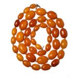 A NECKLACE OF 42 AMBER BEADS 46g