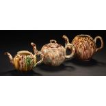 THREE TORTOISESHELL GLAZED CREAMWARE TEAPOTS AND A COVER ONE STAFFORDSHIRE, THE OTHERS POSSIBLY