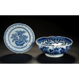 AN ENGLISH DELFTWARE COLANDER BOWL AND A CONTEMPORARY PLATE, C1760-70 painted with floral