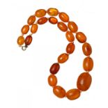 A NECKLACE OF 23 AMBER BEADS 51g ++Small chip and hole in one bead