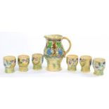 A ROYAL DOULTON BRANGWYN WARE JUG AND SET OF SIX BEAKERS DESIGNED BY SIR FRANK BRANGWYN RA, JUG 22CM